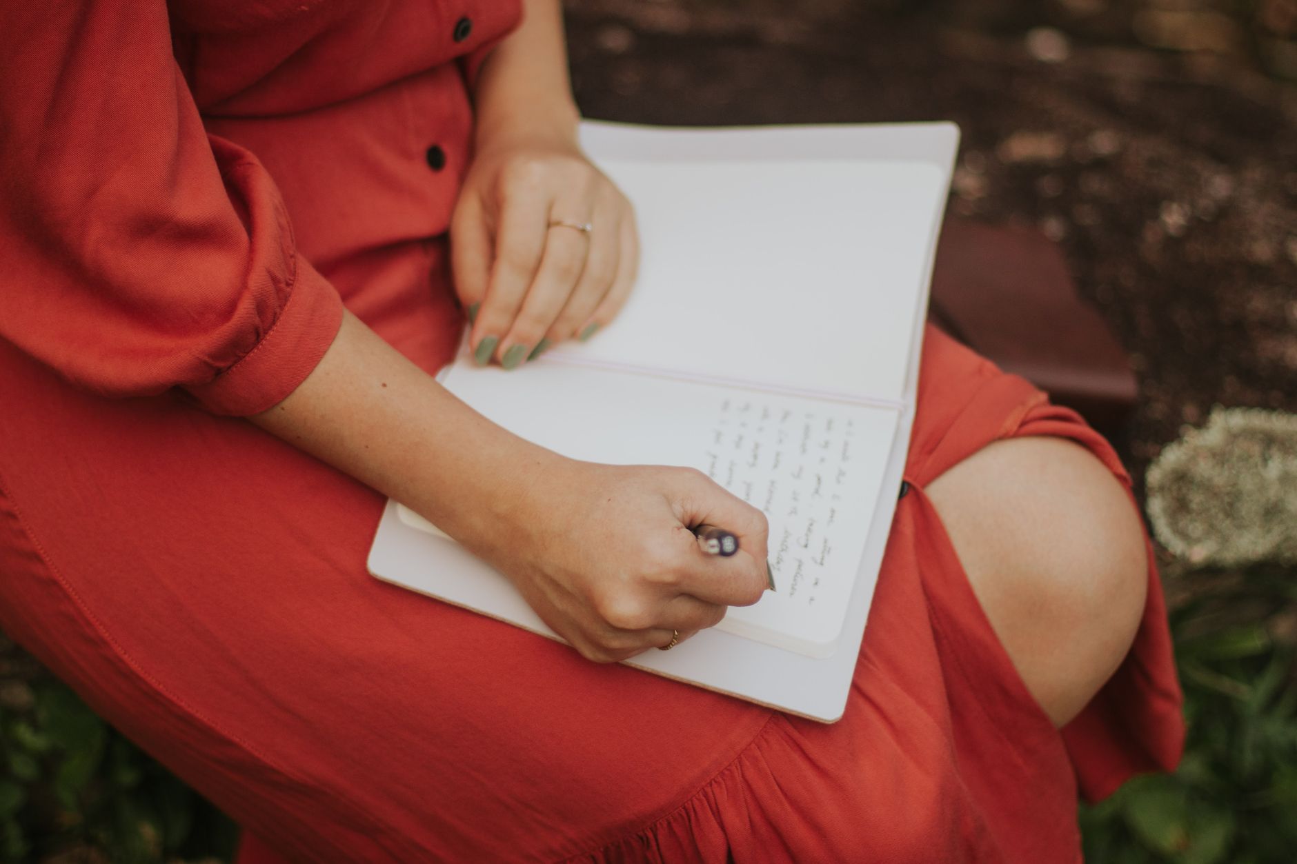 Travel author writing in notebook overlooking mountain valley